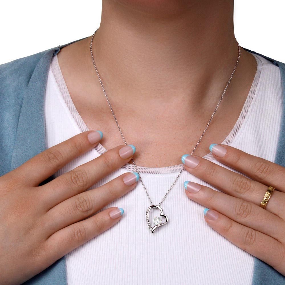 White gold heart necklace on woman's neck close up