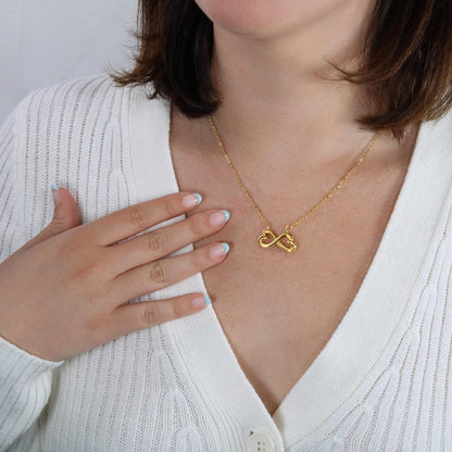 Infinity yellow gold necklace on woman