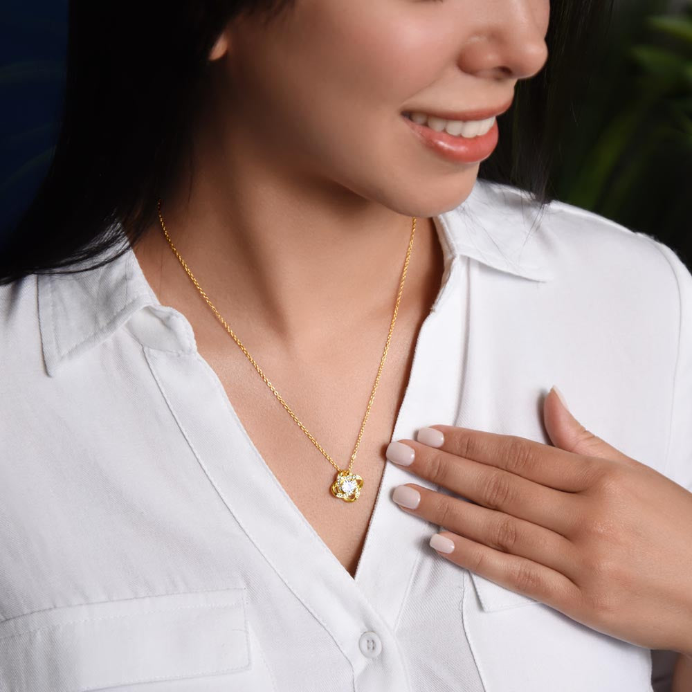knot yellow gold necklace on neck of woman