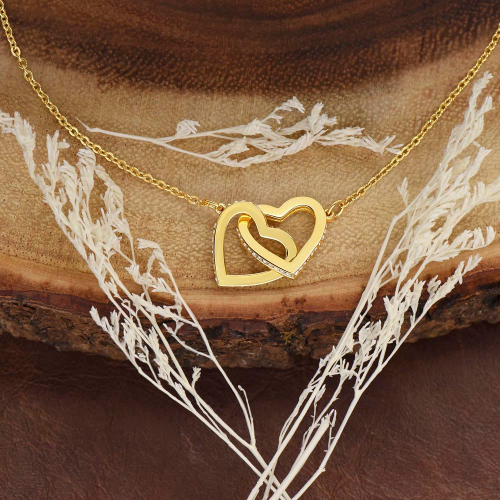 A yellow gold linked hearts necklace close up