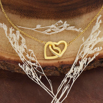 A yellow gold linked hearts necklace close up