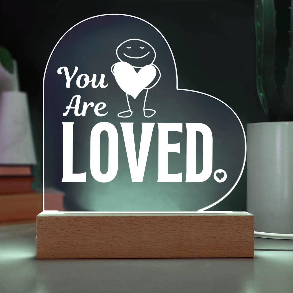 You are loved plaque with a cord sitting on table