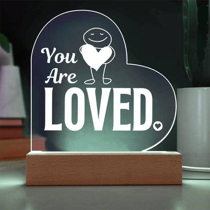 You are loved plaque with a cord sitting on table