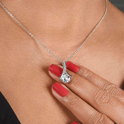 white gold ribbon necklace over woman's hand