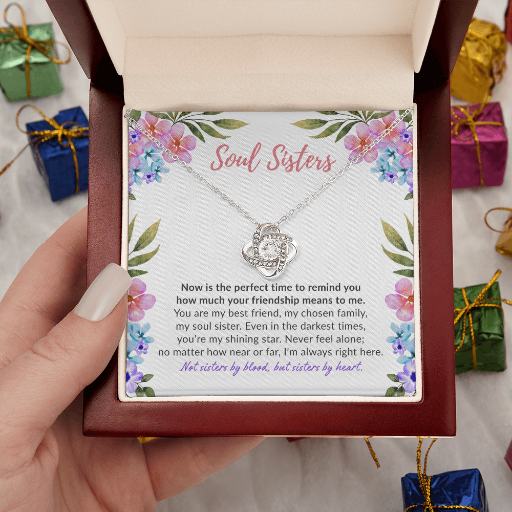 Soul sisters message card with white gold knot necklace in luxury box held by woman's hand.